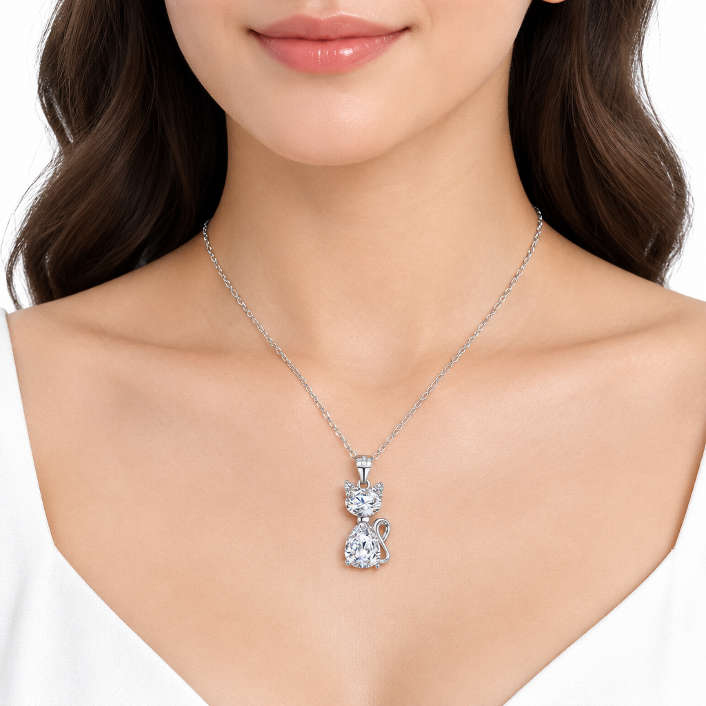 Elegancka modelka z delikatnym srebrnym naszyjnikiem z zawieszką kota z kryształem, łańcuszek ankier, na białym tle