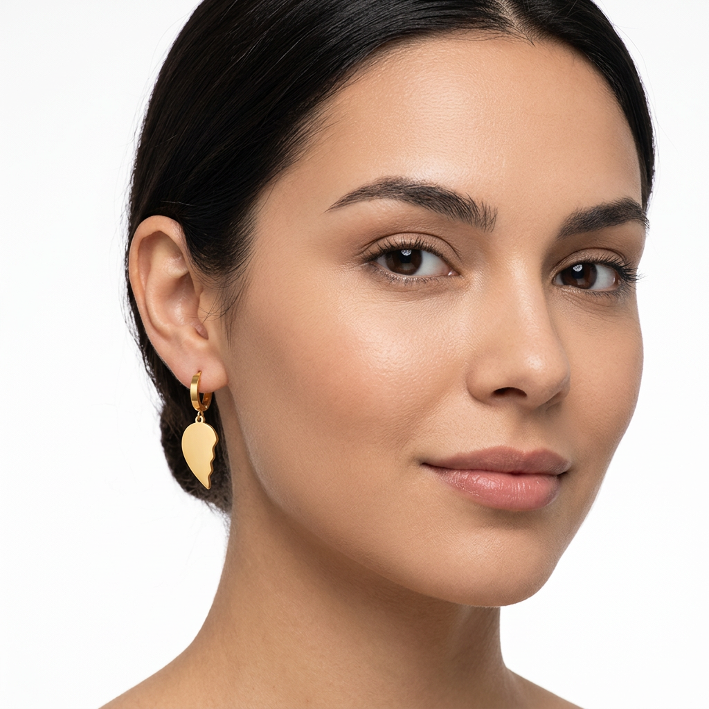 Modelka z kolczykiem w kształcie połówki złotego serca na białym tle