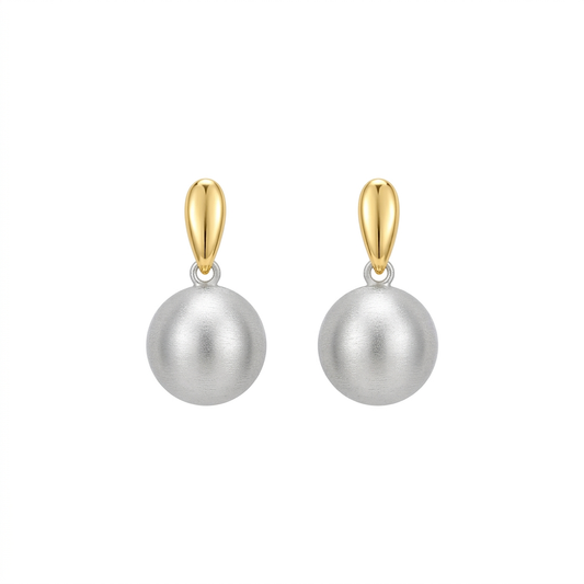 Para kolczyków ze złotymi górnymi elementami i srebrnymi szczotkowanymi kulami na białym tle
